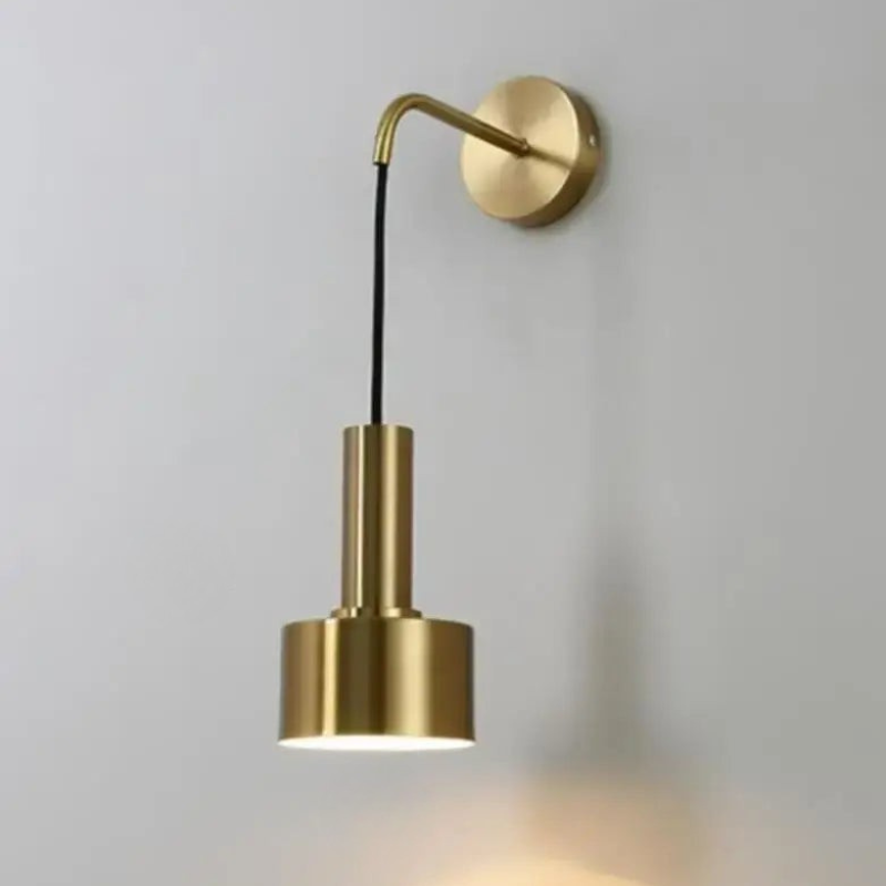 Gold wall-mounted lamp on a plain background
