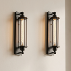 Two black wall sconces with glass covers on a beige wall.