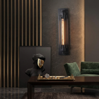 Modern interior with wall sconce, green sofa, and decorative items on a table.