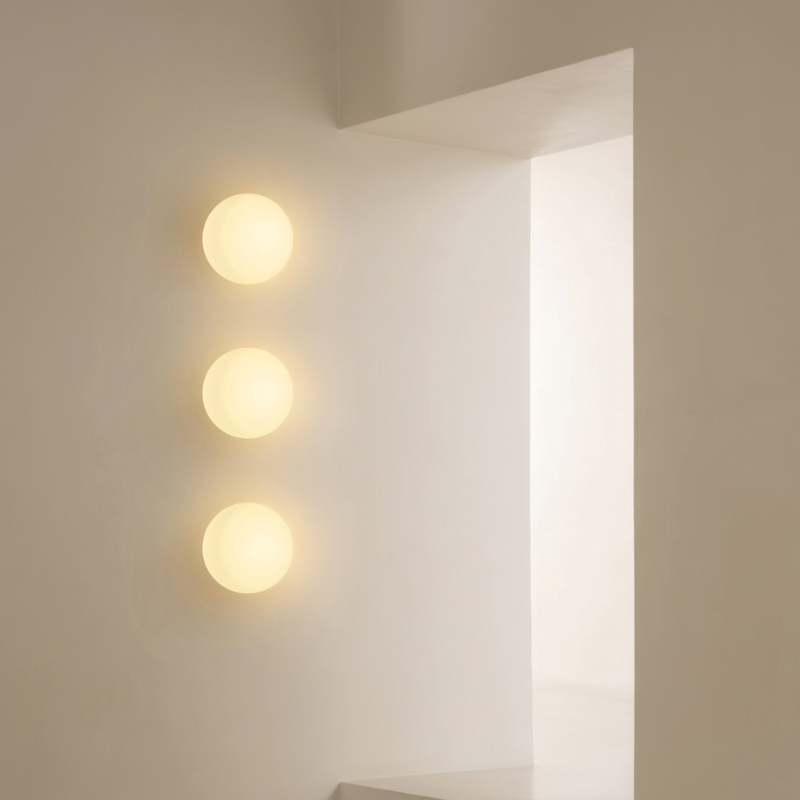 Three round wall lights on a neutral wall