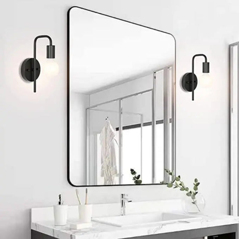 Bathroom vanity with a large rectangular mirror and wall lights.