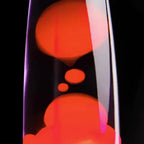 Close-up of a lava lamp with red and orange colors on a black background
