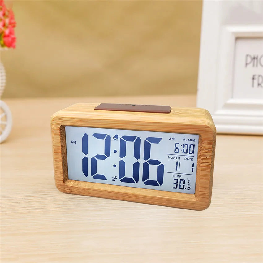 Digital clock with wooden frame on a light surface