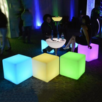 Colorful illuminated cubes on a dark floor with people in the background