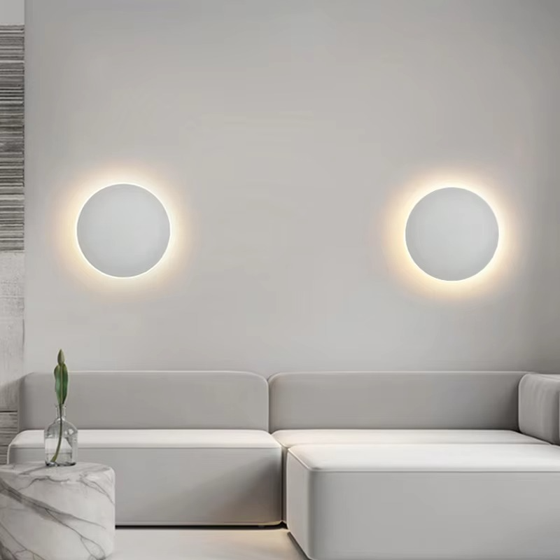 Modern living room with a gray sofa and circular wall lights.