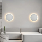 Modern living room with a gray sofa and circular wall lights.