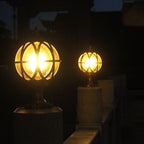Two illuminated spherical lamps on stands against a dark background