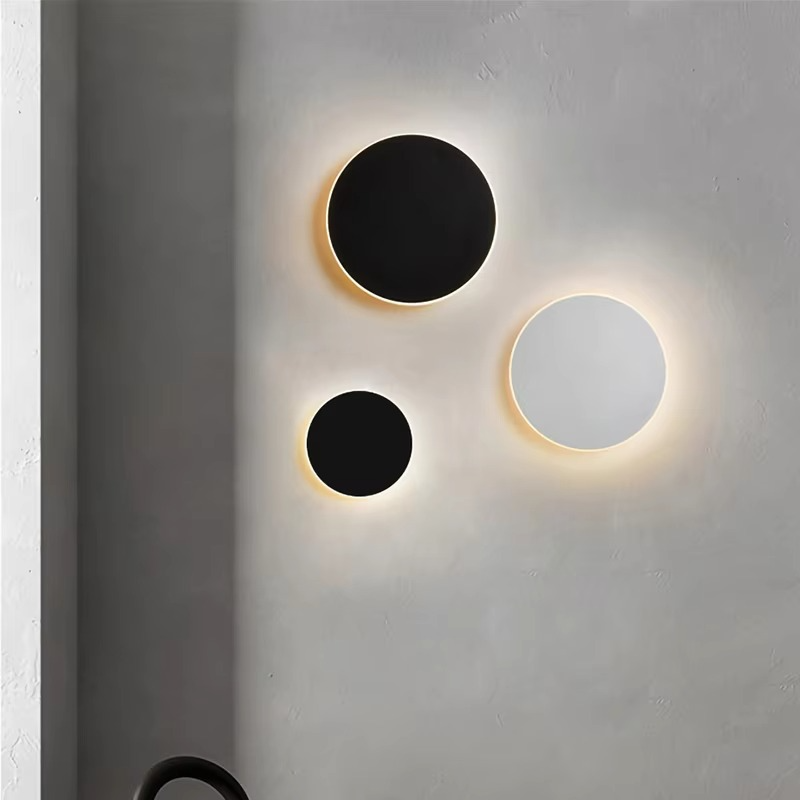 Three circular wall lights on a gray wall