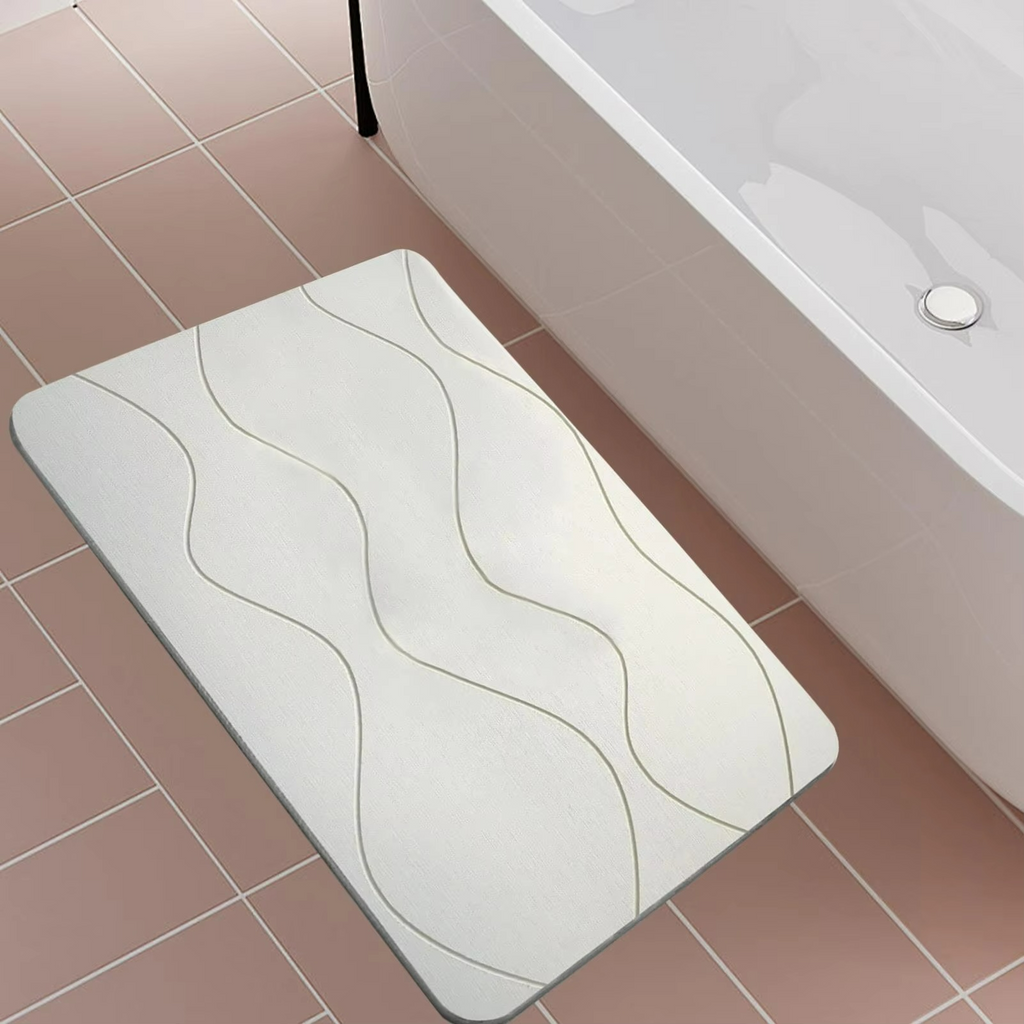 White bath mat with wavy pattern on a tiled bathroom floor.