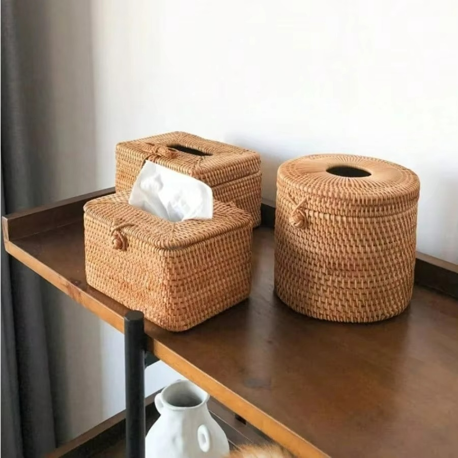 Woven tissue box and basket on a wooden shelf with a white wall background