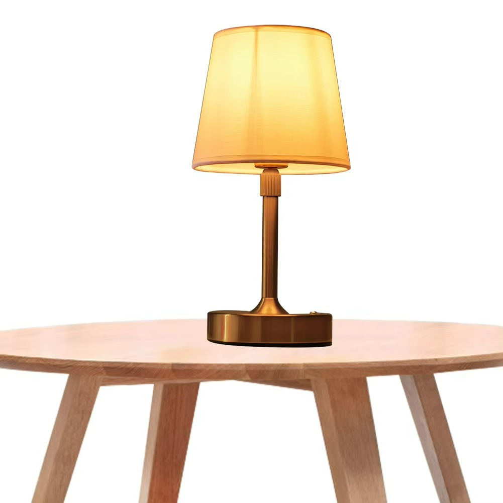 Table lamp with a yellow shade on a wooden table against a white background