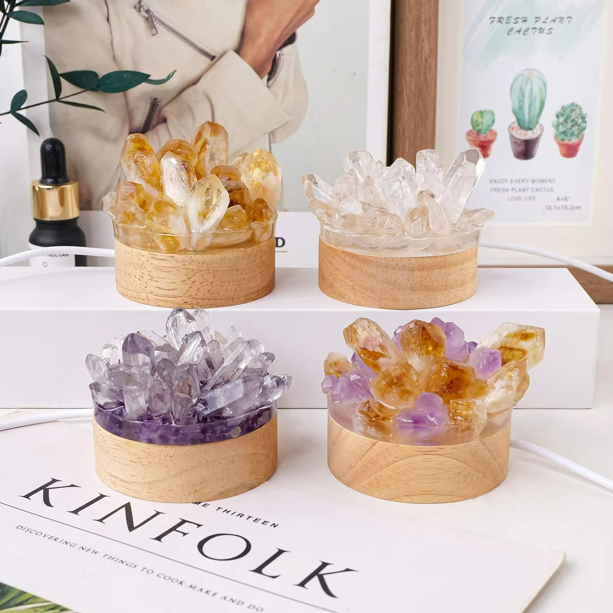 Four crystal containers on a surface with a magazine underneath