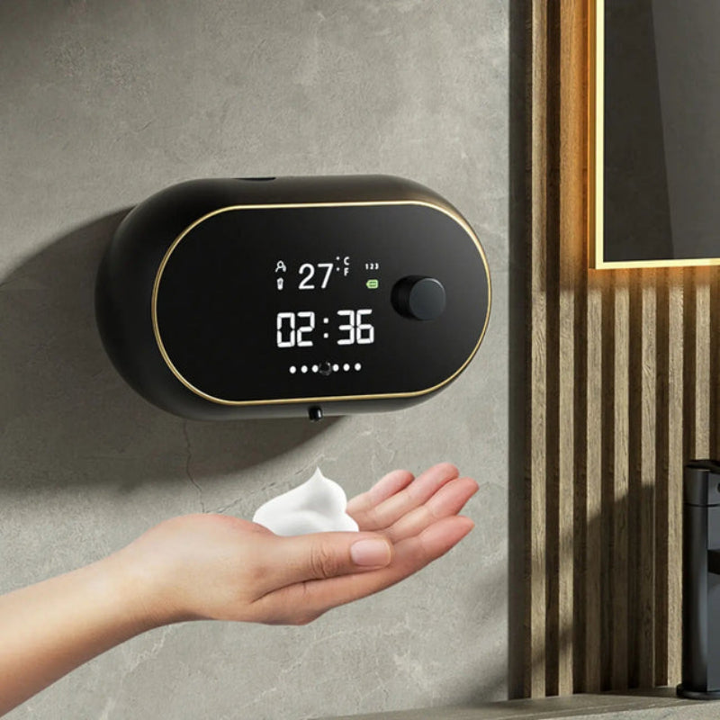 Digital soap dispenser on a wall with a hand reaching out to dispense soap.