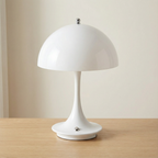 White table lamp on a wooden surface with a plain background