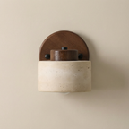 Wall-mounted light fixture with wooden top and beige base on a beige wall.