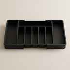 Black plastic tray with compartments on a beige background