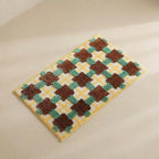 Checkered doormat with brown and green pattern on a beige background