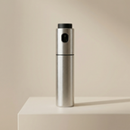 Silver pepper grinder on a beige surface with a beige background