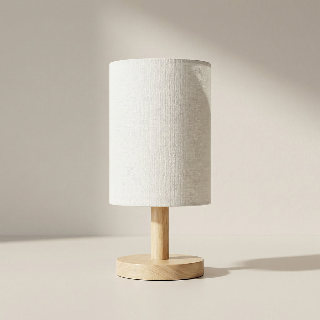 Table lamp with wooden base and white fabric shade on a neutral background