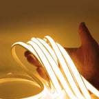 Neon light strip held by a hand against a yellow background