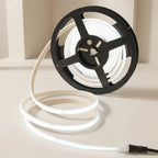 Spool of white LED strip light on a beige background