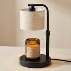 Table lamp with a beige shade and an amber glass jar on a beige background