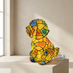 Colorful stained glass dog-shaped lamp on a white surface with a neutral background