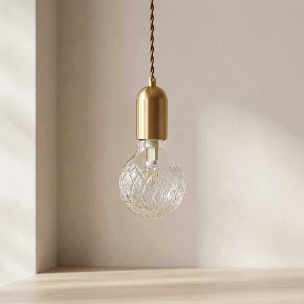 Decorative light bulb with gold fixture against a neutral background