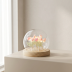 Glass dome with pink flowers on a wooden base against a light background