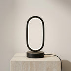 Modern black table lamp with circular design on a light gray background