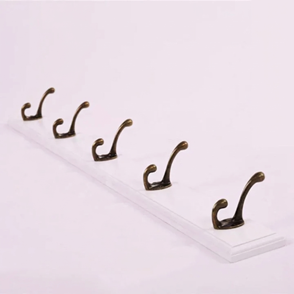 Set of five brass hooks on a white background