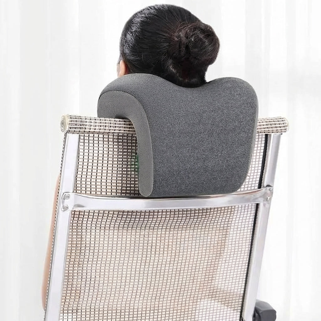 Person using a gray memory foam pillow on a chair against a white background