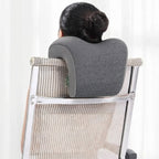 Person using a gray memory foam pillow on a chair against a white background