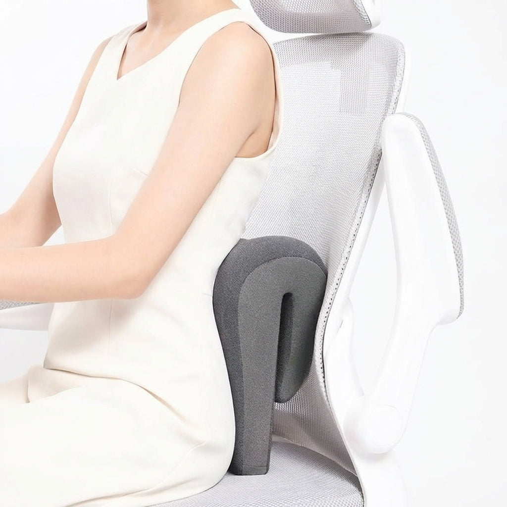 Person using a gray office chair with a headrest and lumbar support pillow.
