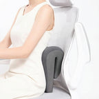 Person using a gray office chair with a headrest and lumbar support pillow.