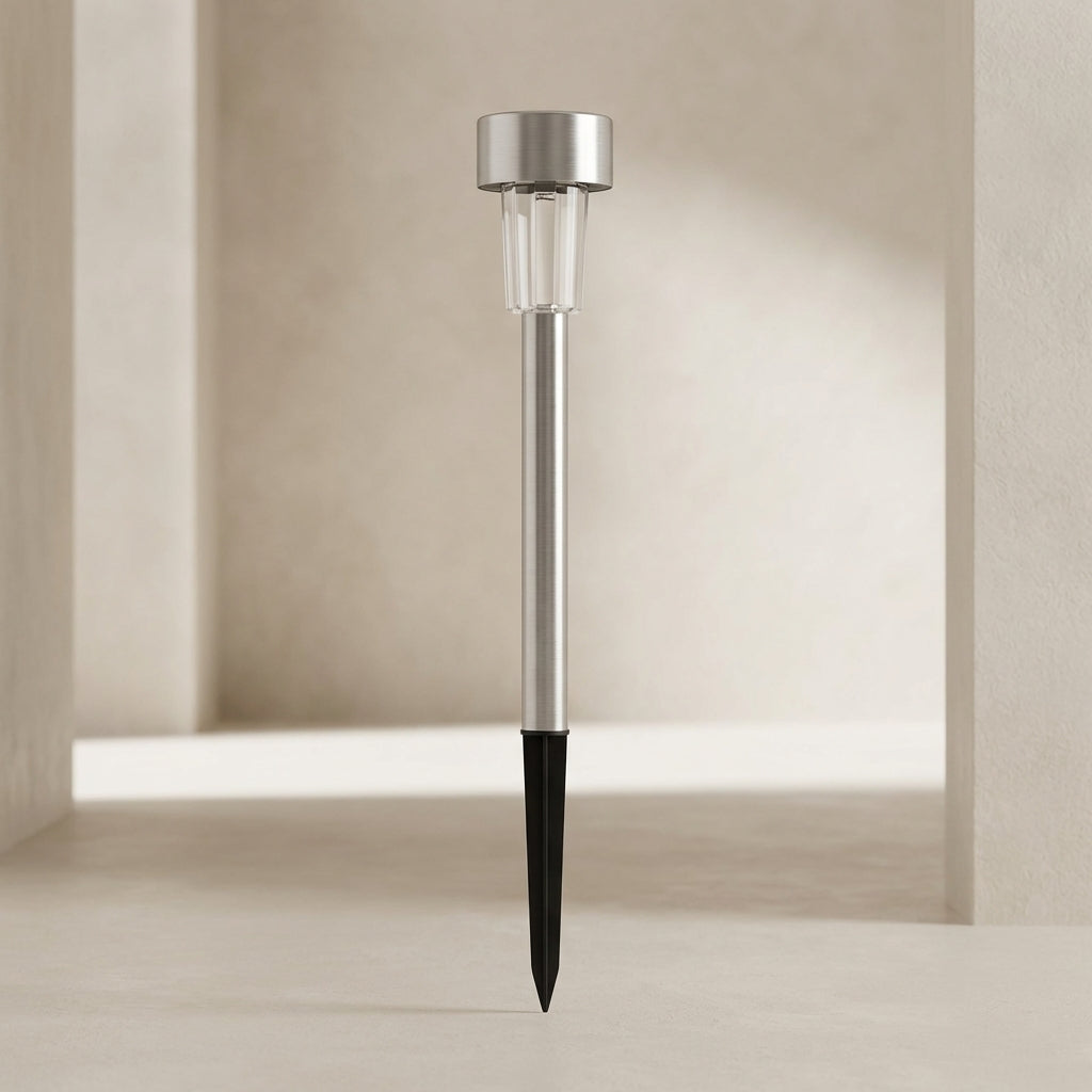 Solar garden light with metallic top and black stake on a neutral background