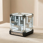Clear cube with black base on a beige surface