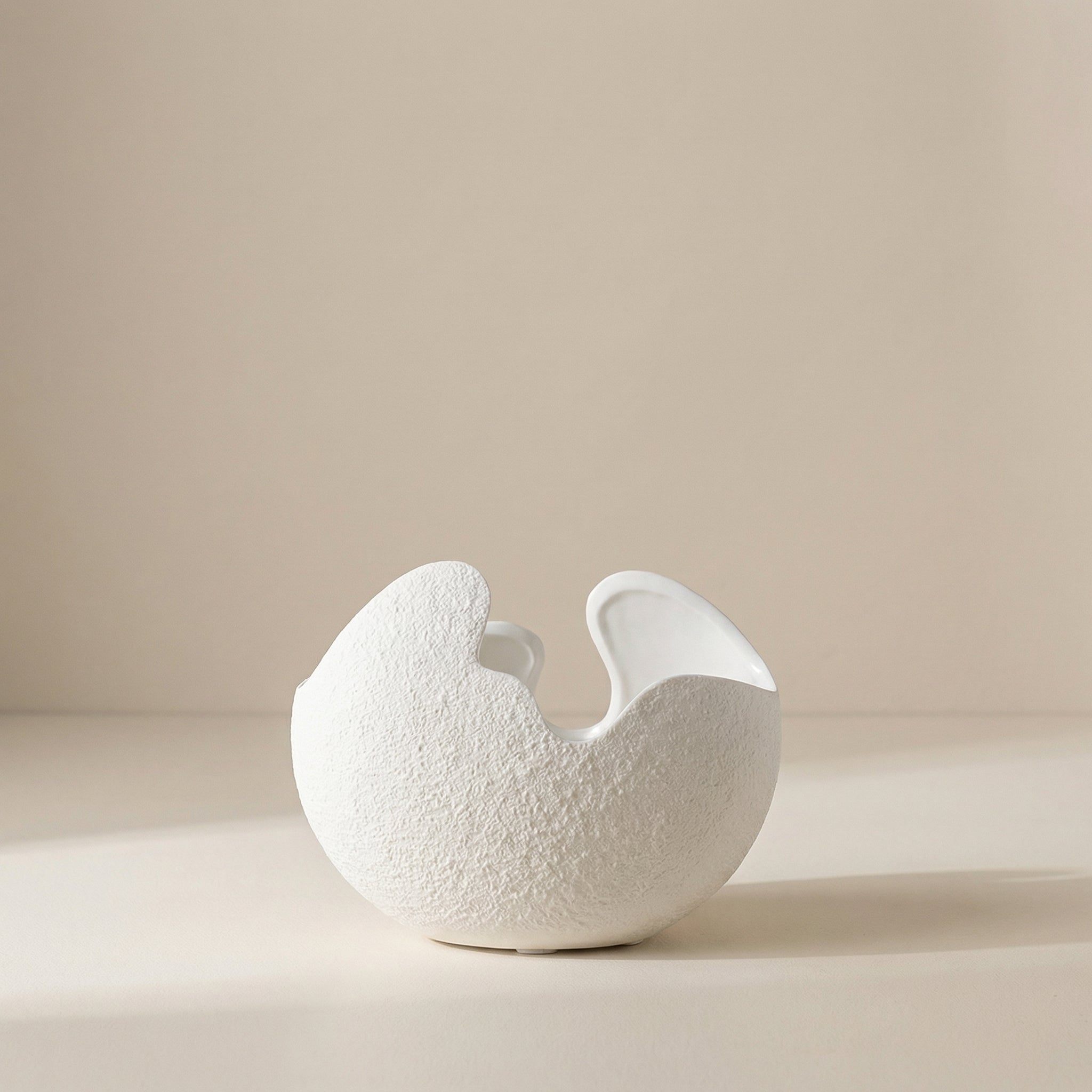White textured ceramic vase on a beige background