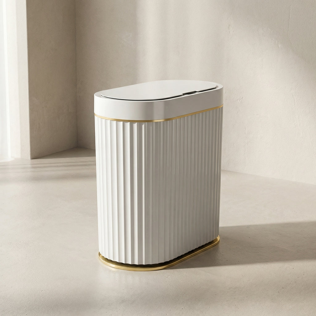 White trash bin with gold accents on a neutral background