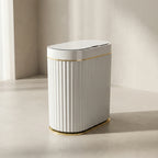 White trash bin with gold accents on a neutral background
