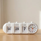 White clock with calendar display on a wooden surface