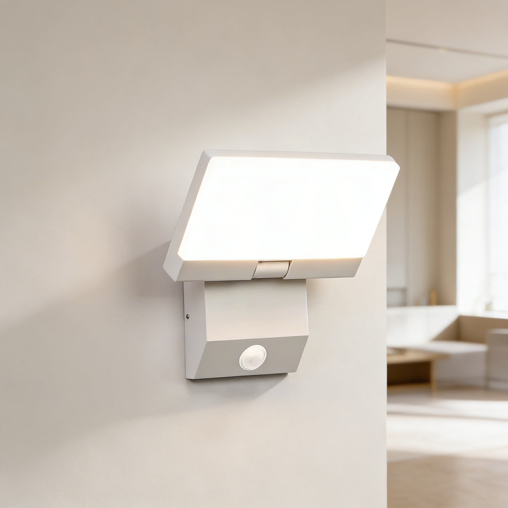 Modern wall-mounted light fixture on a white wall with a blurred room background