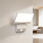 Modern wall-mounted light fixture on a white wall with a blurred room background