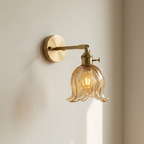 Wall-mounted light fixture with floral glass shade on a neutral wall