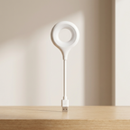 White LED desk lamp on a wooden surface with a neutral background