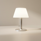 Table lamp with white shade on a beige surface
