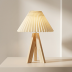 Wooden table lamp with pleated beige shade on a neutral background
