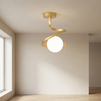 Gold ceiling light fixture with a white bulb in a minimalistic room.