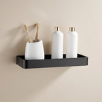 Black wall-mounted shelf with white containers and toothbrushes against a beige wall
