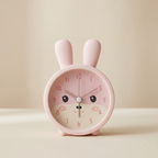 Pink rabbit-shaped alarm clock on a beige background